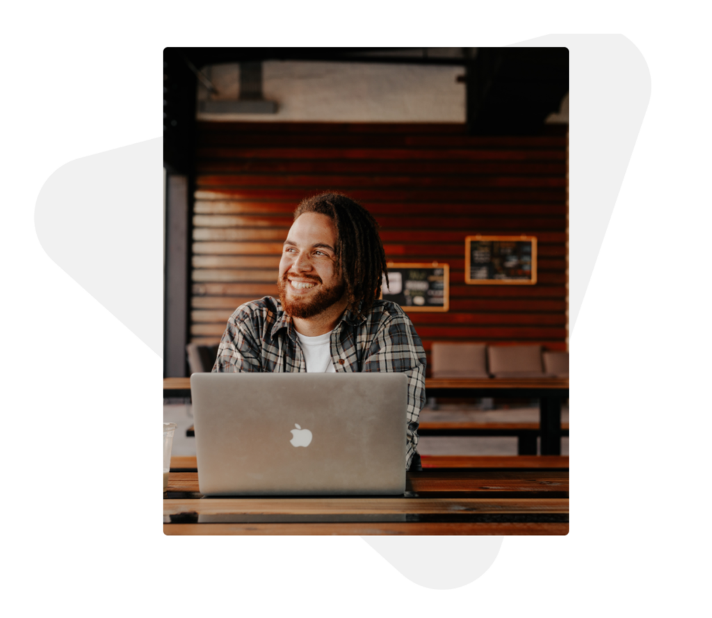 Jovem sorrindo na frente do computador